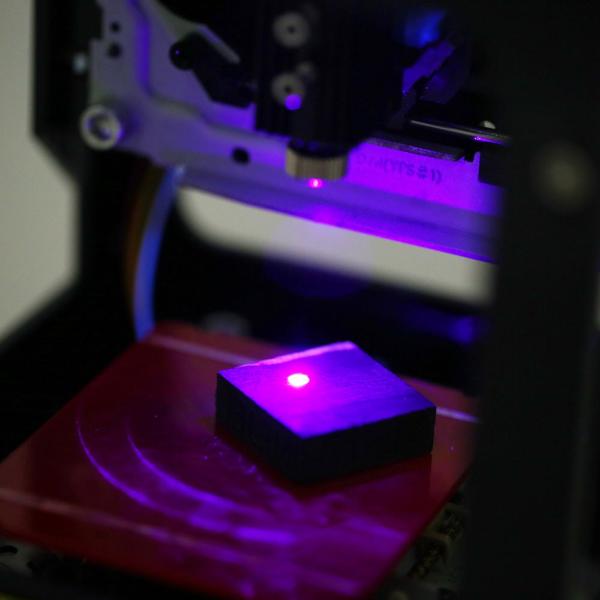 3D printer with a purple light on a dark background
