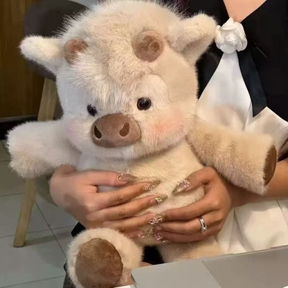 CreamCuddle cream Highland cow plush held in a person’s arms, showing brown horns and hooves
